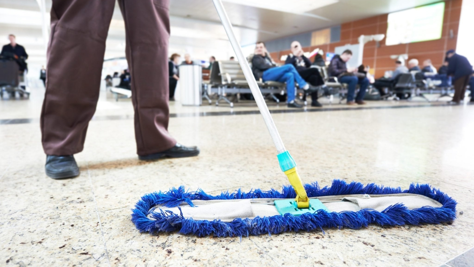 Professional janitor mopping an airport floor for cleanliness and hygiene